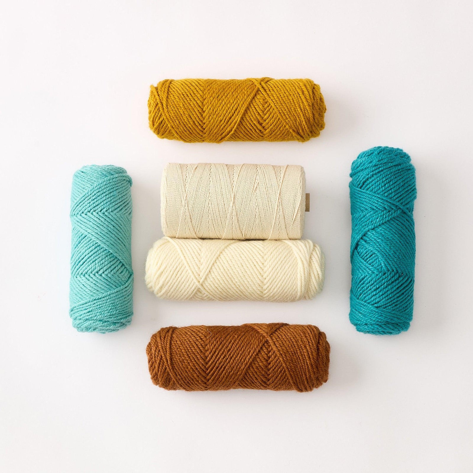 Five tubes of Dwella Rug Wool featured alongside one tube of cotton warp twine