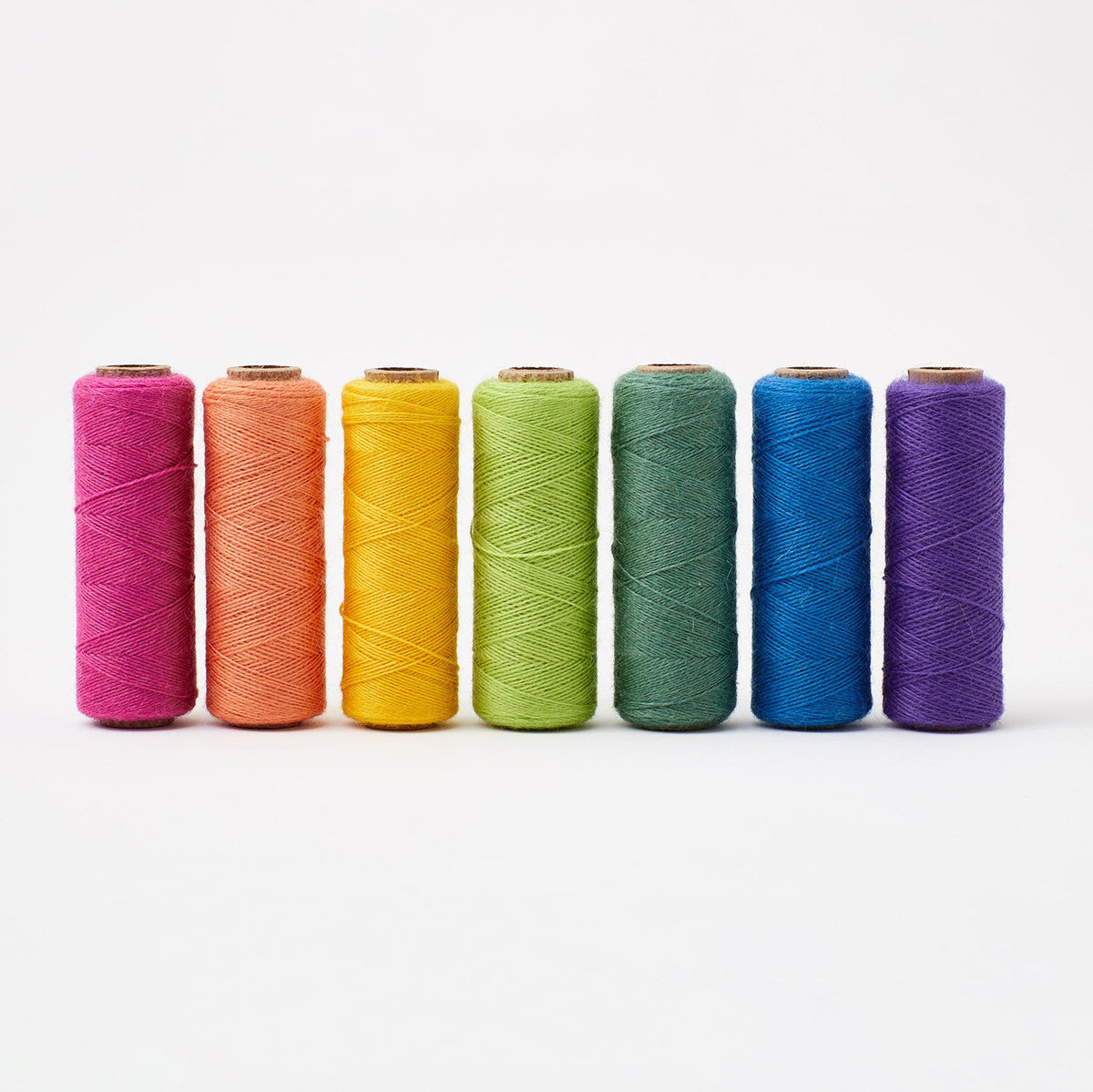 Array Rainbow Sampler Pack showing seven colorful wool yarn spools in vibrant rainbow hues on white background
